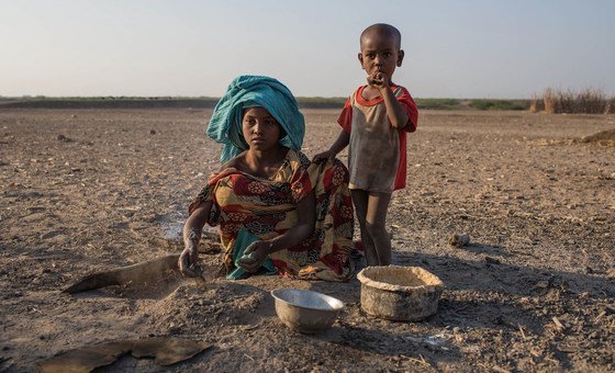 A young girl cooks in a rural village in Ethiopia, where the land has been affected by recurrent droughts. 