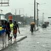 People walk through downtown Port-au-Prince during a tropical storm.