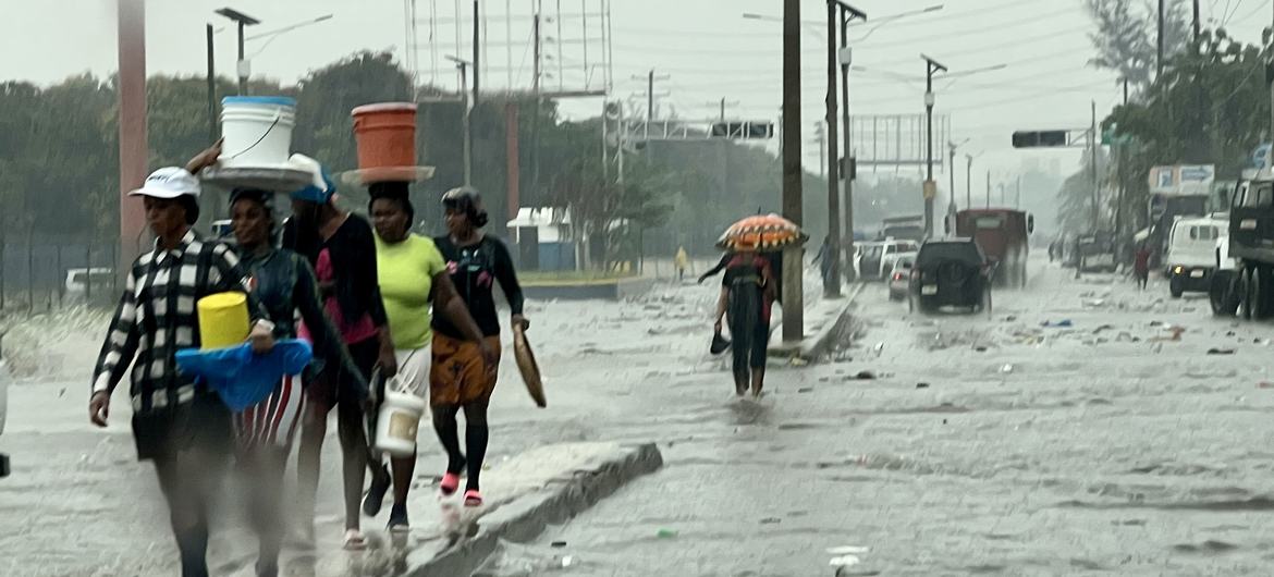 Pessoas caminham pelo centro de Porto Príncipe durante uma tempestade tropical