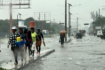 Pessoas caminham pelo centro de Porto Príncipe durante uma tempestade tropical