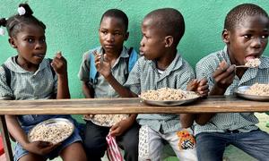 Children in Haiti eat a meal provided as part of WFP's school feeding programme.