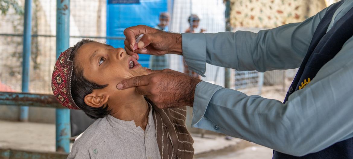 अफ़ग़ानिस्तान में तोर्खम बॉर्डर पर एक बालक को यूनीसेफ़ समर्थित स्वास्थ्यकर्मी द्वारा पोलियो की बूंदें दी जा रही हैं.