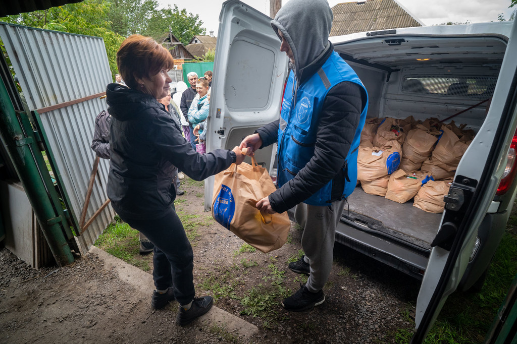Un colis alimentaire est livré à une femme en Ukraine.
