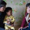 उत्तर कोरिया में, एक स्वास्थ्यकर्मी, एक परिवार से मिलते हुए.