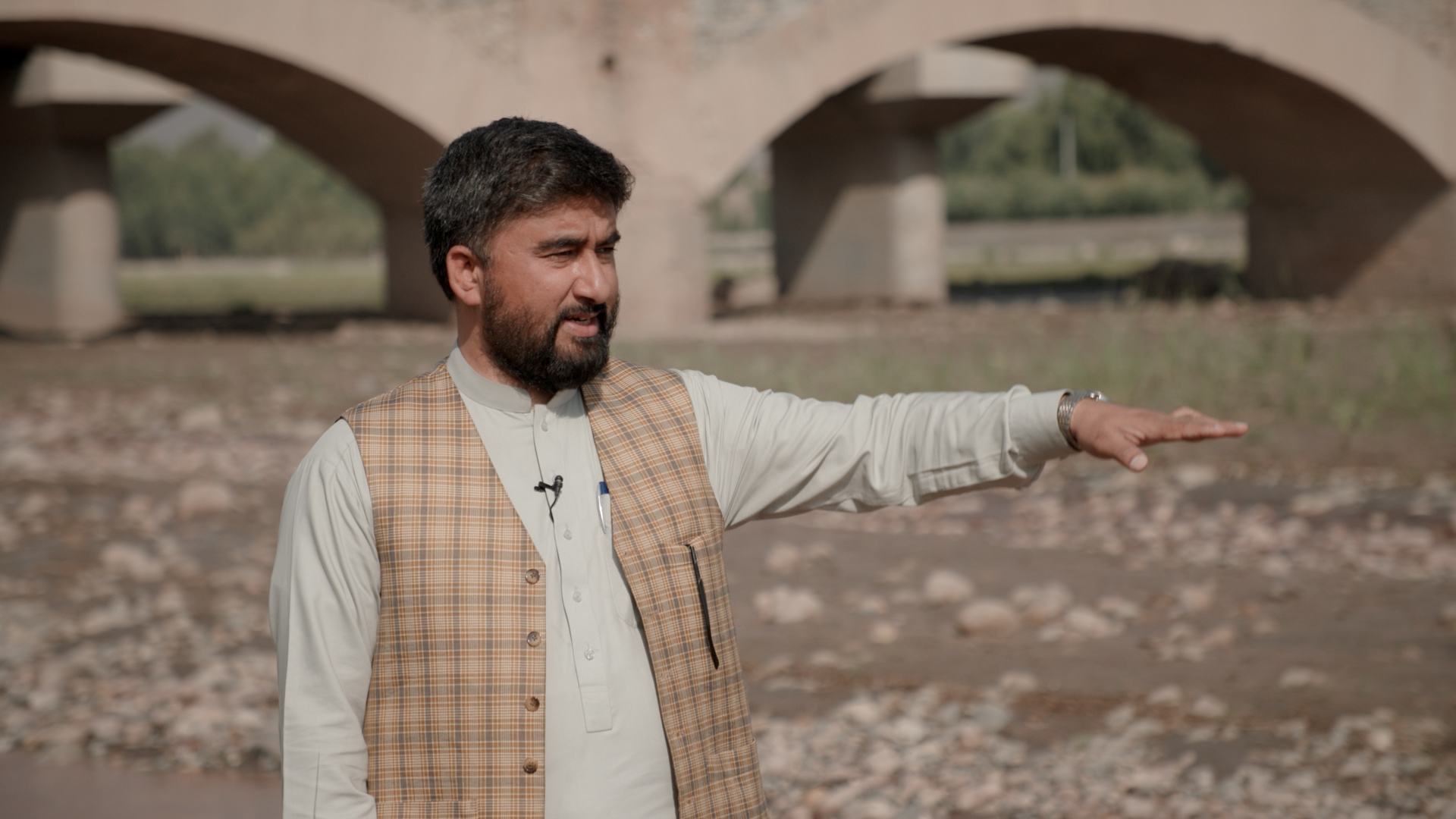 هداية الله سابي من مكتب الأمم المتحدة المعني بالمخدرات والجريمة يقف على ضفاف "النهر الأحمر" الجاف في المنطقة الشرقية من أفغانستان.