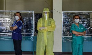 Wearing a full protective suit, a women doctor leads a group of volunteer medical professionals attending to COVID-19 patients at a community hospital in the Philippines.