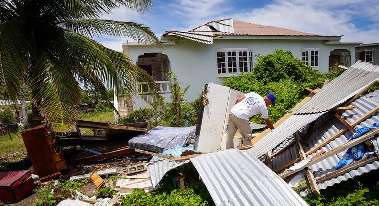 Equipe da OIM avalia uma casa gravemente danificada pelo ciclone Beryl na Jamaica.