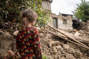 A six-year-old girl looks at the ruins of her home, destroyed in the 31 August earthquake in eastern Afghanistan.