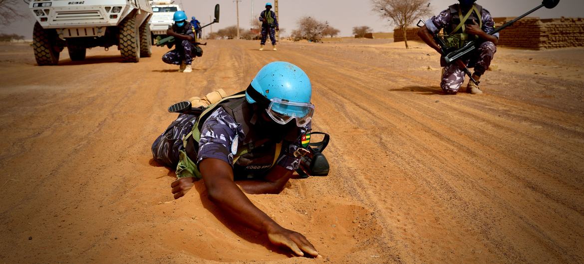 أحد أعضاء فريق البحث والكشف الذي يعمل مع بعثة الأمم المتحدة لتحقيق الاستقرار في مالي يعاين طريقا في ميناكا في شمال شرق مالي.