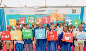 Students in Tanzania hold Sustainable Development Goals (SDG) cards.