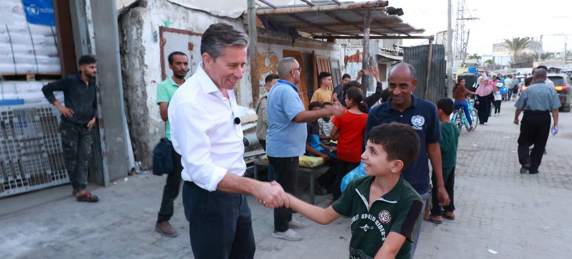 توم فليتشر، وكيل الأمين العام للأمم المتحدة للشؤون الإنسانية يسلم على صبي فلسطيني في غزة.