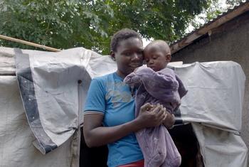 Beatrice Nabwire Okumu kutoka Busia akiwa na mtoto wake nje ya hema lao baada ya kukumbwa na mafuriko. Yeye ni mnufaika wa msaada wa lishe kutoka UNICEF Kenya.