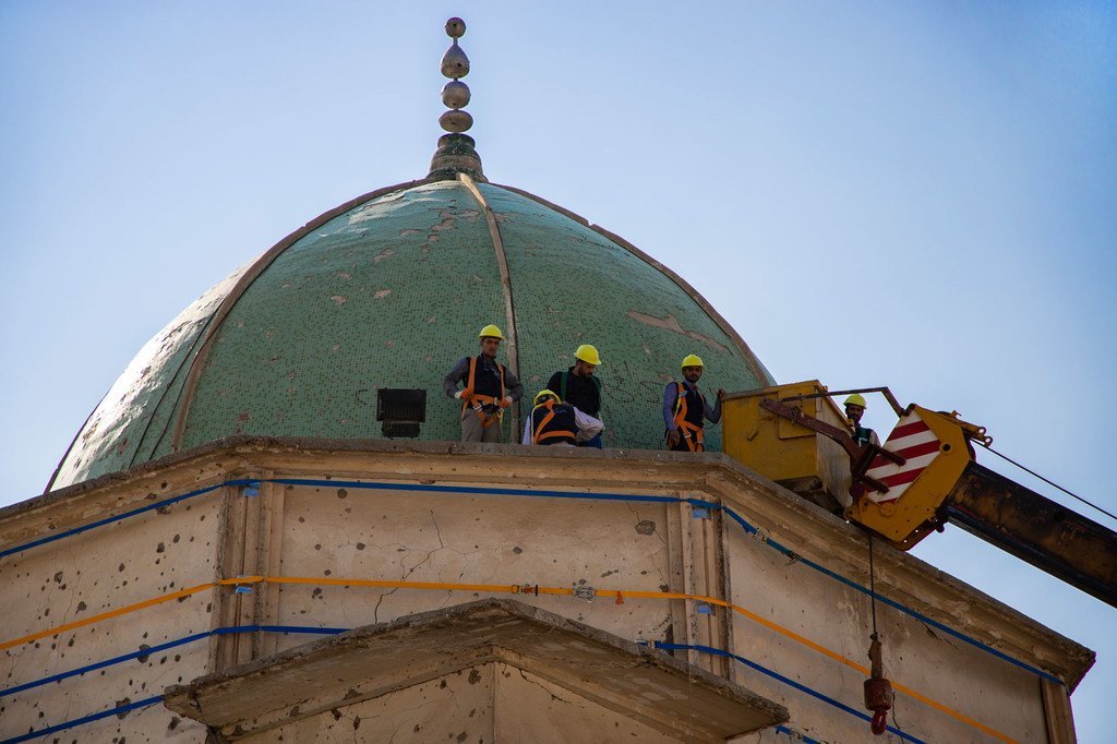 عمال بناء على قبة مسجد خلال أعمال إعادة الإعمار في الموصل، العراق.