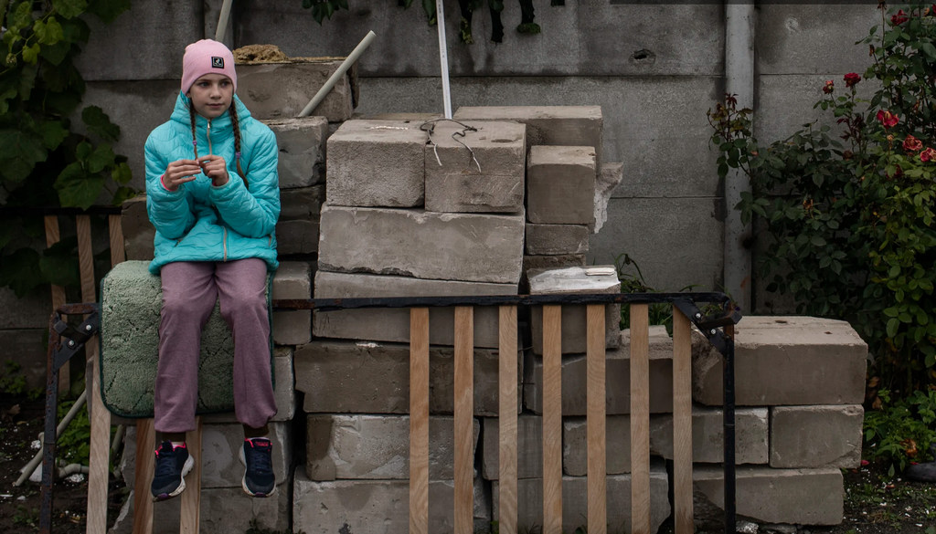 Una niña de nueve años descansa mientras ayuda a su madre a limpiar su casa, en su mayor parte destruida por los bombardeos en Chernihiv, Ucrania.