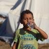A five-year-old boy drinks bottled water delivered by UNICEF in the Khan Younis camp in Gaza..