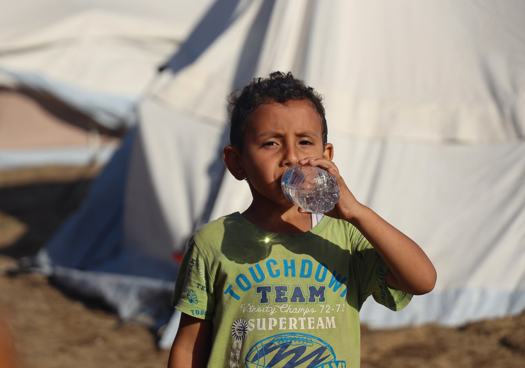 طفل يبلغ من العمر خمس سنوات يشرب المياه المعبأة التي قدمتها اليونيسف في مخيم خان يونس في غزة.