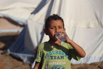 A five-year-old boy drinks bottled water delivered by UNICEF in the Khan Younis camp in Gaza..