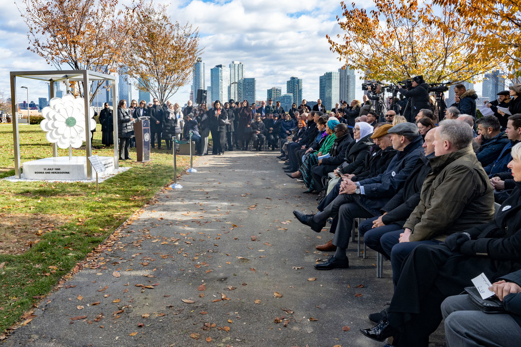 Le secrétaire général de ONU prend la parole lors d'un dépôt de fleurs en hommage aux victimes du génocide de Srebrenica, devant un public assis dans un parc extérieur de Toronto.