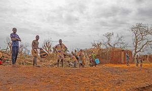 People affected by Tropical Cyclone Chido stand in front of damaged property.