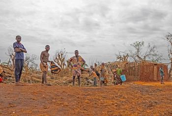 People affected by Tropical Cyclone Chido stand in front of damaged property.