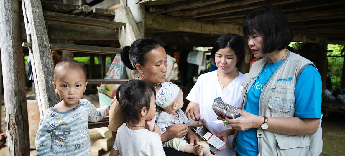 A family in Tuyên Quang province in Viret Nam is provided with nutritional supplements by a UNICEF worker.
