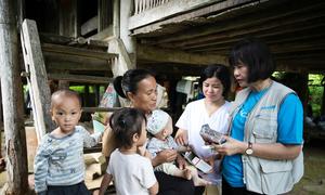 A family in Tuyên Quang province in Viret Nam is provided with nutritional supplements by a UNICEF worker.