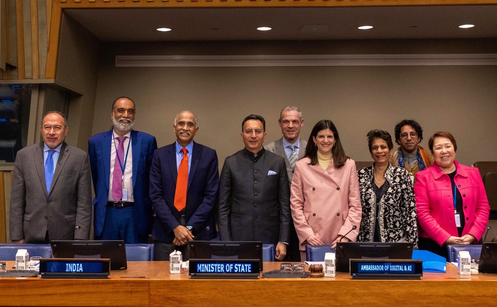 एआई इम्पैक्ट समिट के पूर्वाभ्यास के रूप में आयोजित 'फ्रॉम एक्शन टू इम्पैक्ट' कार्यक्रम के लिए भारत और फ्रांस के आठ अधिकारी न्यूयॉर्क में UN मुख्यालय में एक कॉन्फ्रेंस टेबल के पीछे खड़े हैं।