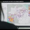 Um monitor de computador exibe um mapa da Amazônia brasileira mostrando o risco de desmatamento, com visualizações de dados e porcentagens na tela.