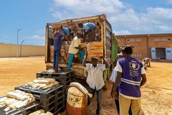 在尼日尔，人们从卡车上卸下食品援助。