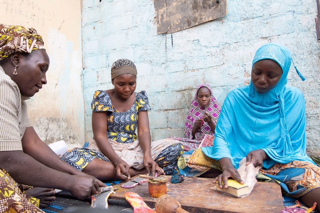 境内流离失所者阿米纳图·萨利（右）是喀麦隆人，她接受了一个非政府组织的皮革制品制作培训。 
