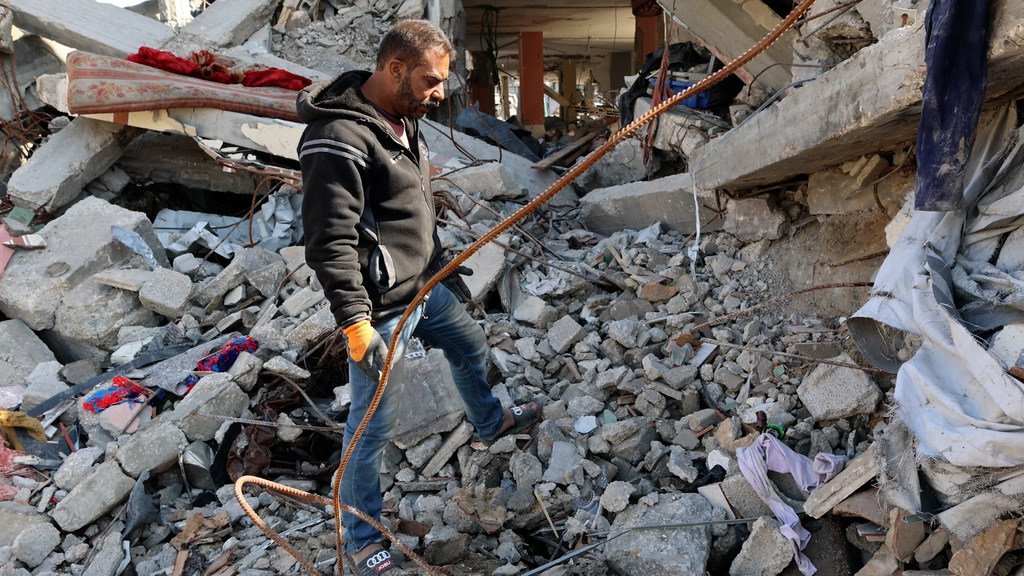 Un hombre camina entre los escombros de un edificio destruido en Gaza.