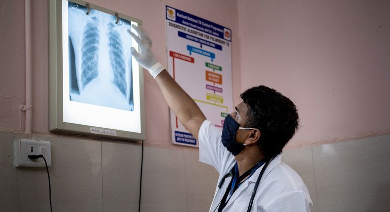  في ولاية غوجارات بالهند يقوم بفحص الأشعة السينية لصدر أحد المرضى بحثا عن علامات السل أو التهابات أخرى في الرئة.