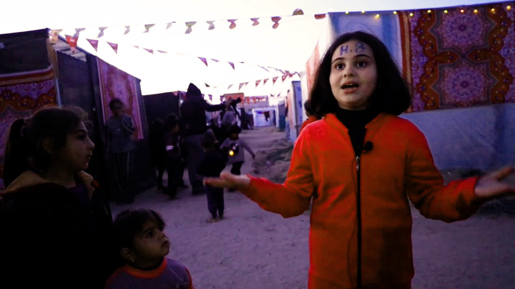 شهد، طفلة نازحة تعيش مع أسرتها في مخيم مؤقت للنازحين في مدينة دير البلح، وسط غزة.