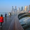 在中国青岛的一个“智能低碳能源”区，人们走在桥上。