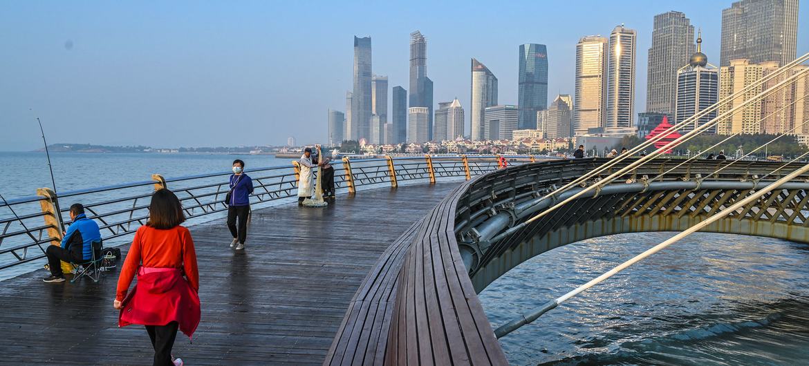 在中国青岛的一个“智能低碳能源”区，人们走在桥上。