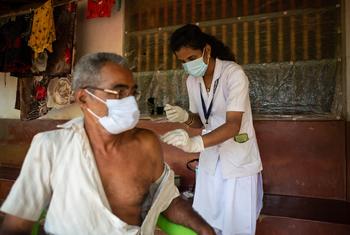 Un trabajador sanitario de la India vacuna a un anciano contra el COVID-19. 