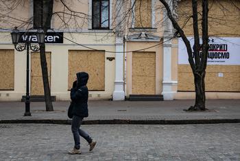 A woman walks past boarded-up stores in Odessa, Ukraine.