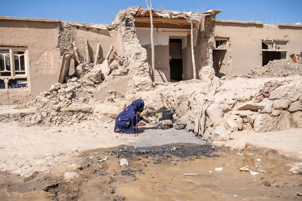 Mwanamke akiwachemshia maji watoto wake sita nje ya nyumba yake iliyoharibika kufuatia mafuriko katika Mkoa wa Baghlan kaskazini mwa Afghanistan.