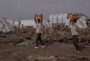 صبيان صغيران يحملان وعائين ملآها في نقطة لتوزيع المياه أنشأتها اليونيسف وشركاؤها في مخيم بولينجو، غرب مدينة غوما بجمهورية الكونغو الديمقراطية.