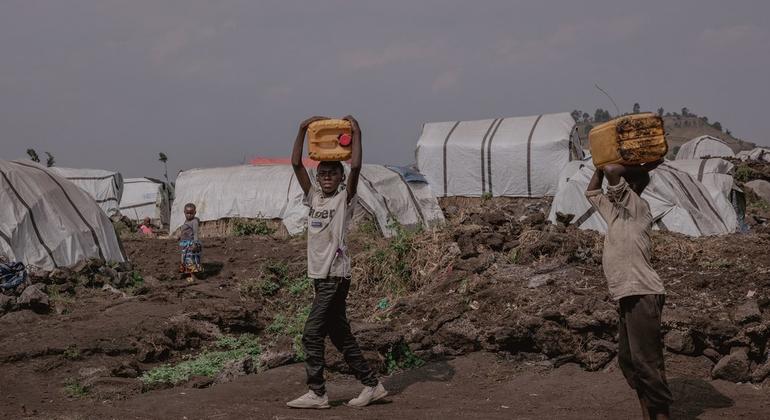 Two young boys carry jerry cans they have filled at a water distribution point set up by UNICEF and its partners in Bulengo camp, west of the city of Goma, Democratic Republic of Congo.