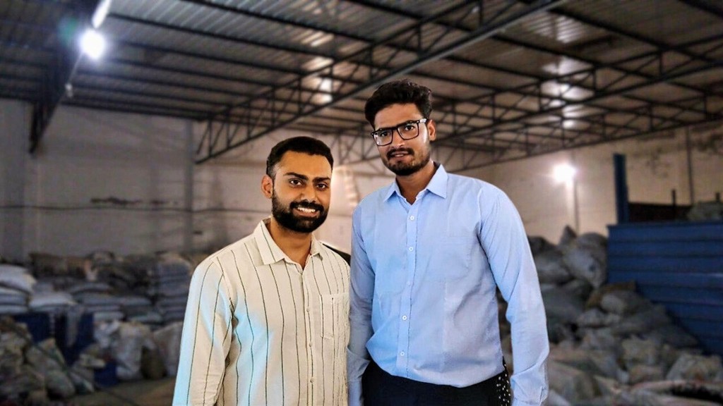 इंजीनियर ऋषभ पटेल और नितिन यादव प्लास्टिक कचरे की थैलियों से भरे एक गोदाम में एक साथ खड़े हैं।