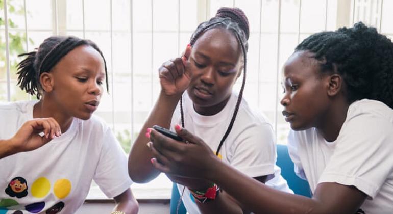 Meninas que são membros do conselho consultivo de jovens, em Nairobi, analisando o aplicativo OKY.
