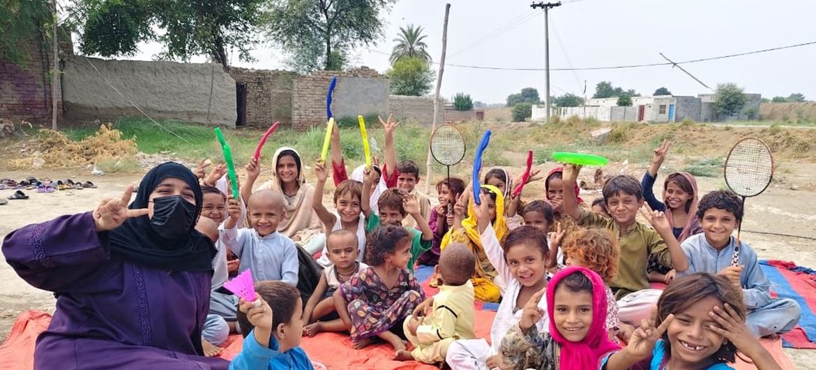 پنجاب، پاکستان کے سیلاب سے متاثرہ علاقوں میں UNICEF کارکنان اور بچے، بچوں کے لیے موزوں جگہ میں حصہ لے رہے ہیں۔
