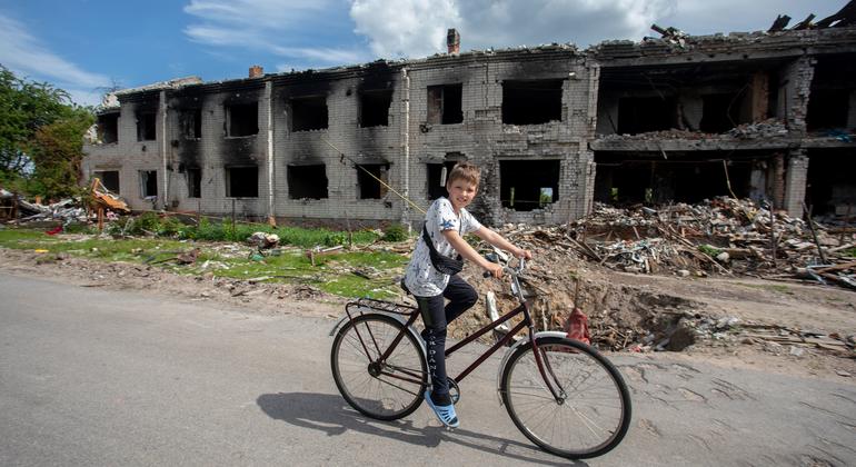 A boy rides his bike past destroyed homes in Chernihiv, Ukraine.