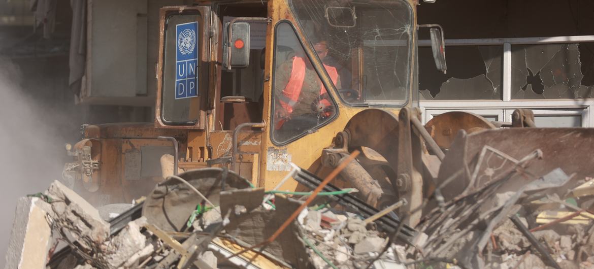 Escavadeira do Pnud removendo destroços da Rua Al-Jalaa, no centro da Cidade de Gaza
