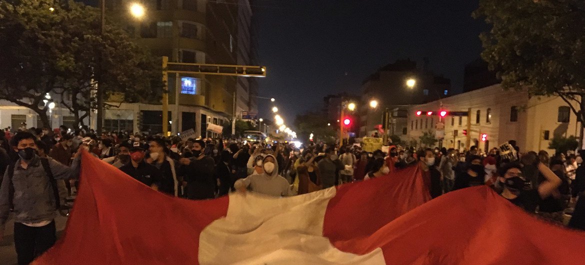 Manifestantes agitam uma bandeira gigante do Peru.