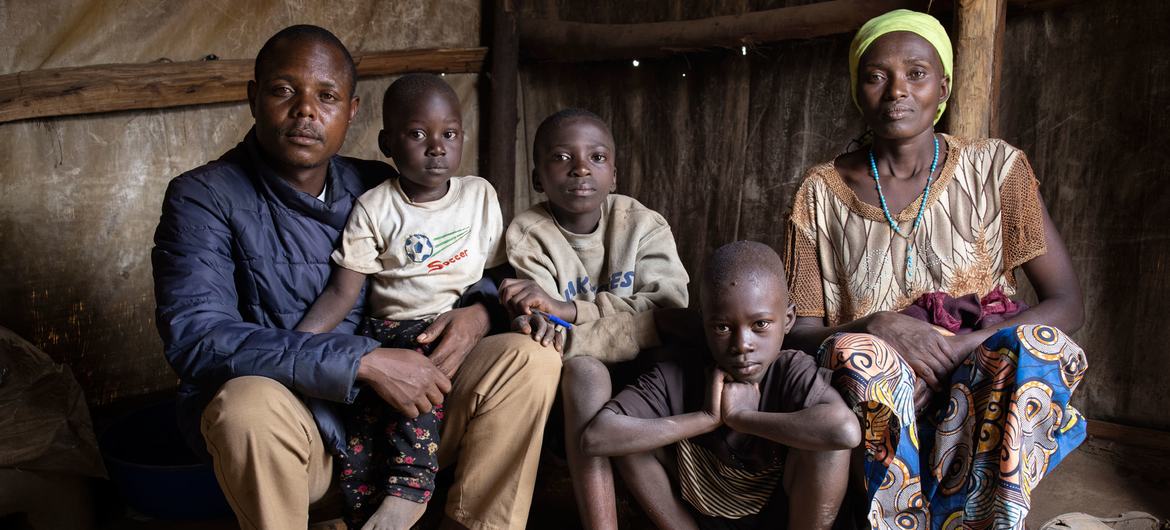 A family sit in their shelter in DR Congo’s Ituri province, following a deadly attack on the camp in February 2022.