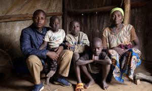 A family sit in their shelter in DR Congo’s Ituri province, following a deadly attack on the camp in February 2022.