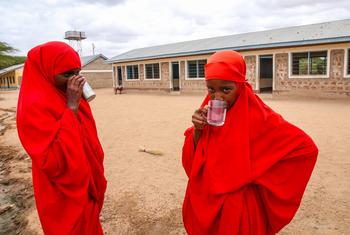 केनया के डाले गाँव में दो छात्राएँ, यूनीसेफ़ के समर्थन से संचालित स्वच्छ व सुरक्षित पेयजल केन्द्र पर. 