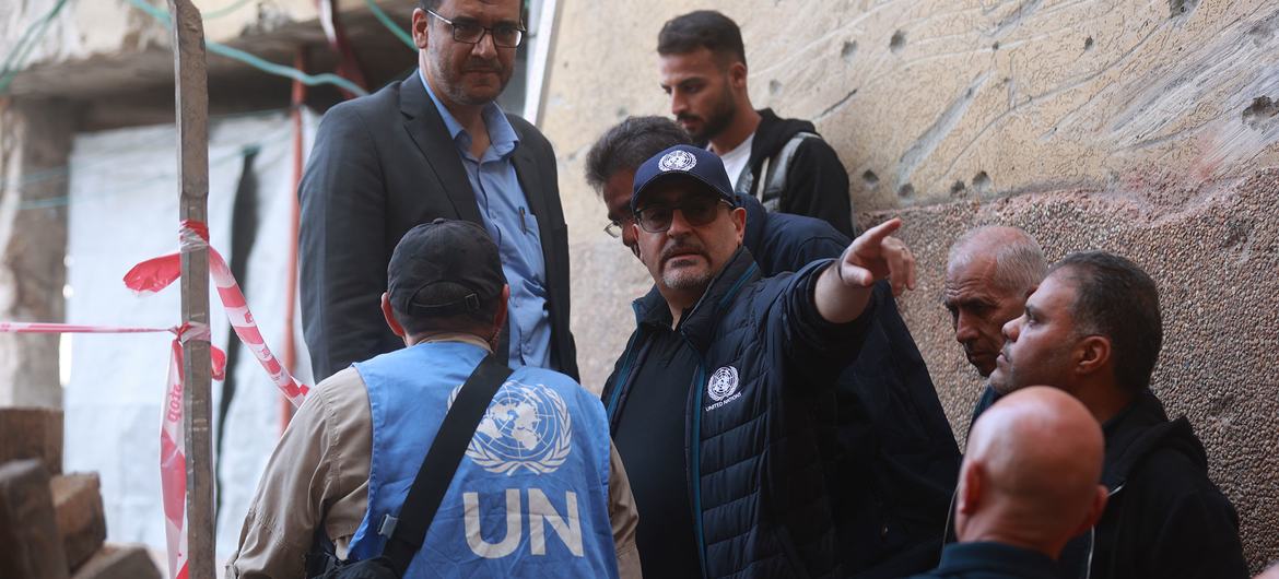 الأمين العام الأمم المتحدة أنطونيو غوتيريش وموظفو الأمم المتحدة يتفقدون مبنى مدمرًا في غزة.